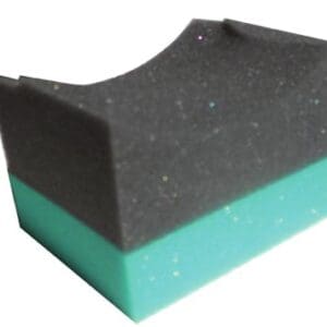 A black and green sponge is sitting on top of another