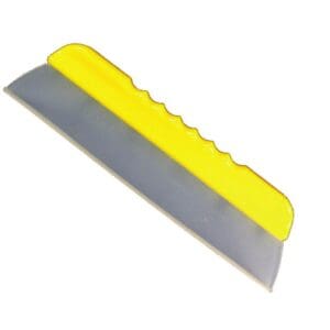 A yellow and gray plastic blade is laying on the ground.